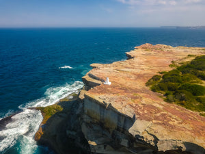 Stock image of waterfront cliff and white obelisk marker at Shark Point in Sydney